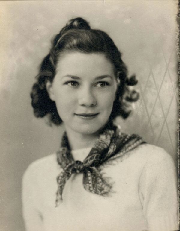 Woman with scarf posing elegantly.
