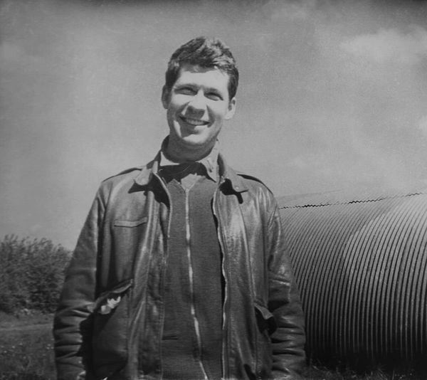 Smiling man in flight jacket.
