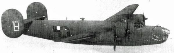 Aircrew posing before large aircraft.
