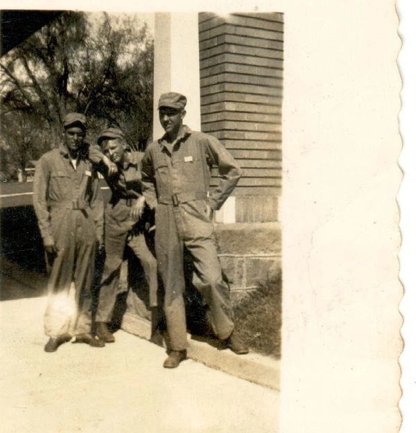 Three soldiers standing outdoors together.