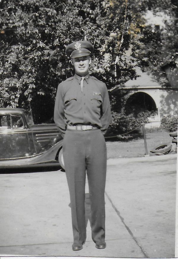 Man in uniform standing outside.