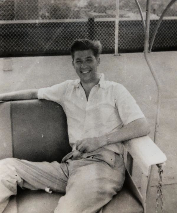 Smiling man sitting on bench.
