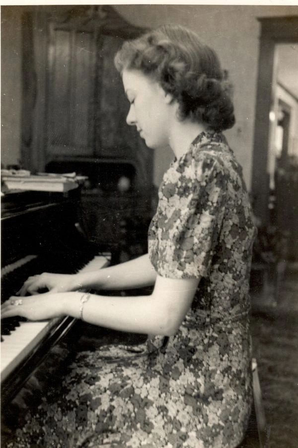 Woman playing the upright piano.