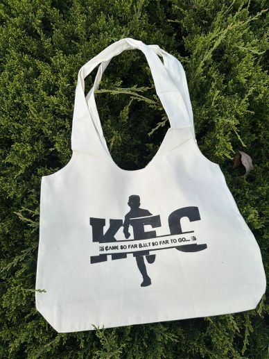 White tote bag with a runner silhouette and motivational text.