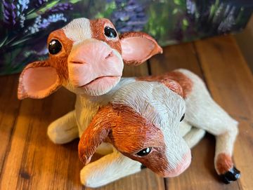a two headed calf sculpture made of polymer clay and painted ivory with red brown spots