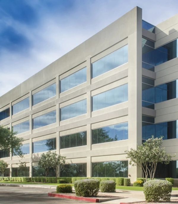 Modern office building with large windows and landscaping.
