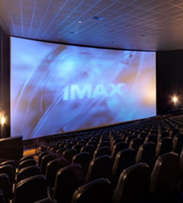 Empty IMAX theater with a large screen and rows of seats.