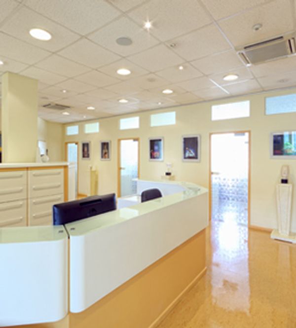 Modern, clean reception area with desk and chairs.