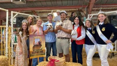 Group of people at livestock show holding rabbits.