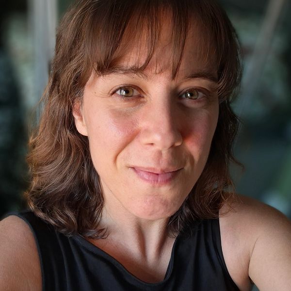 Close-up portrait of a woman with brown hair and a gentle smile.
