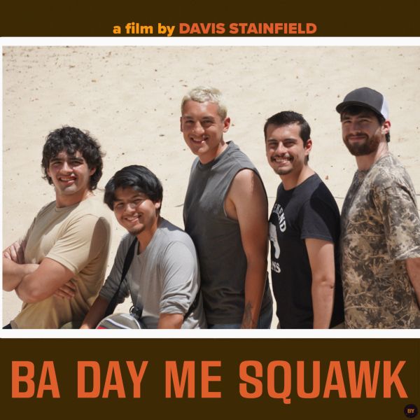 Five men posing and smiling in a desert setting for a film poster.
