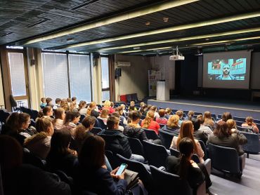 Audience watching a presentation in a lecture hall.