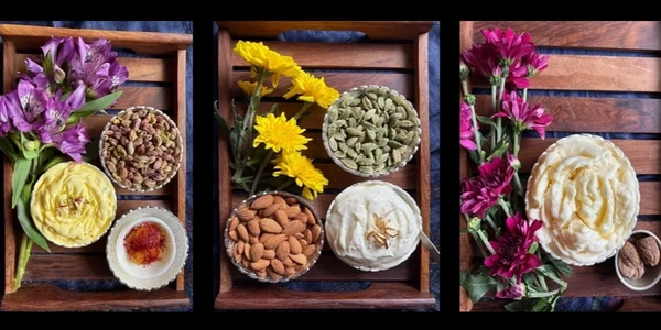 Badam Elaichi Shrikhand : Three wooden trays with flowers, nuts, spices, and creamy dishes.