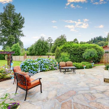 A cleaned patio with flower bushes and chairs