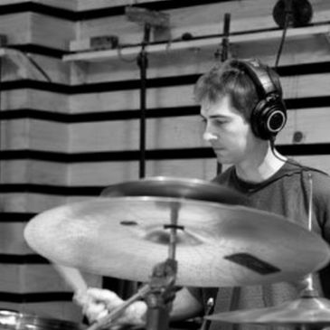 Drummer wearing headphones playing drums.