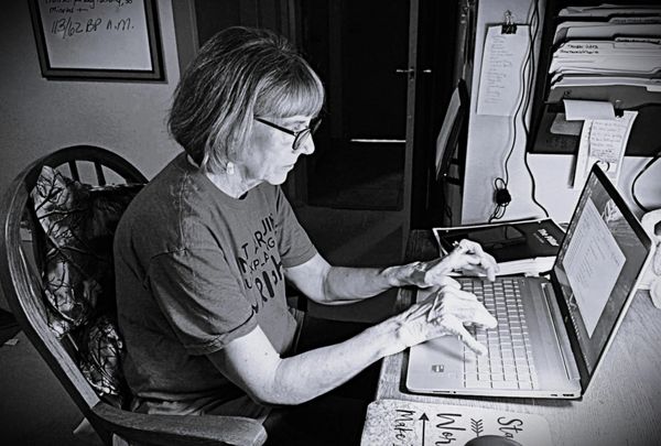 Woman typing on a laptop at a desk.