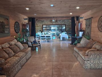 Cozy rustic room with patterned sofas and a dining area in the background.