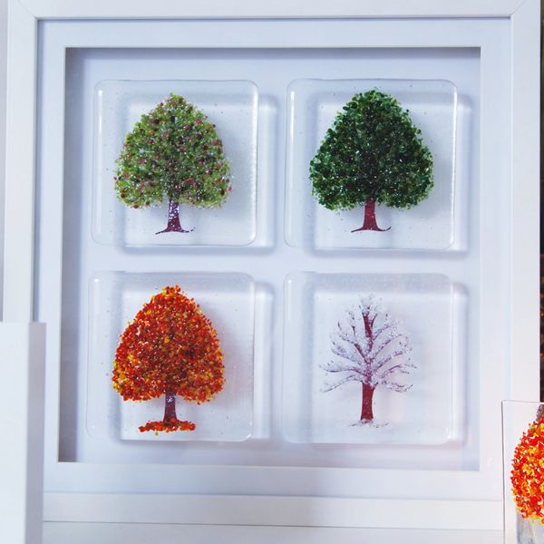 large framed four seasons trees in white frame standing on tabletop