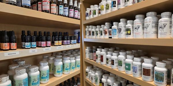Shelves stocked with various essential oils and supplement bottles in a health store.