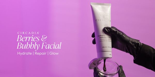 Hand in black glove dispensing Circadia Berries &amp; Bubbly Facial cream against a purple background.