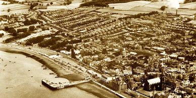 Aerial view of a historic coastal town with a pier.