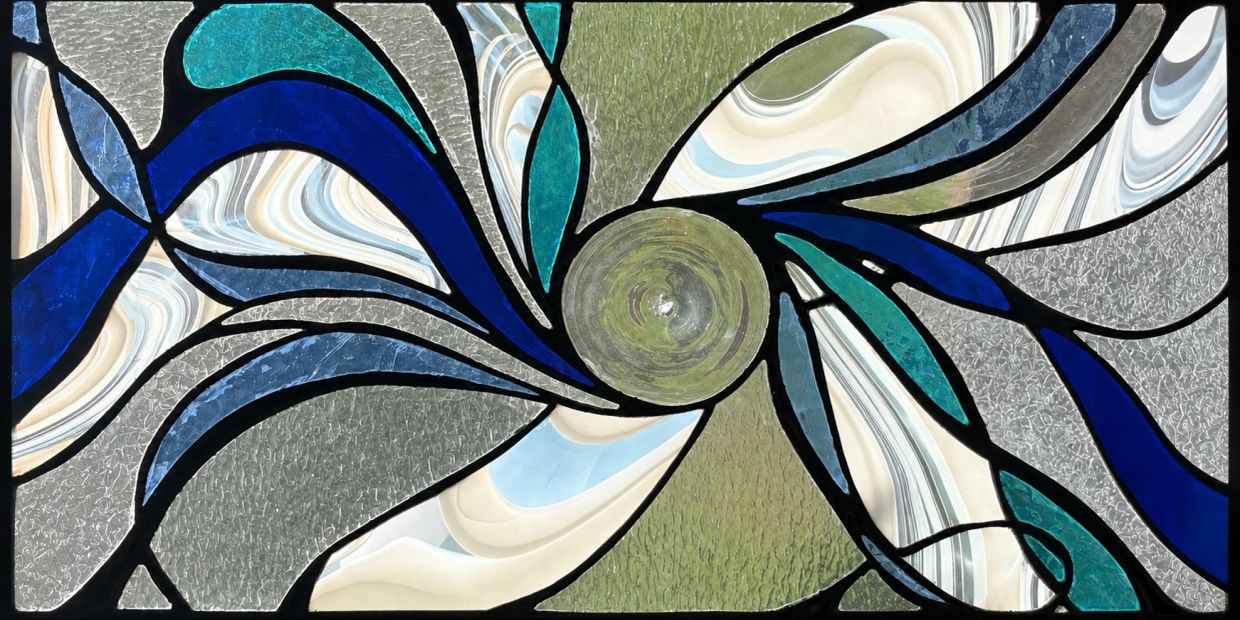 Abstract stained glass window with swirling patterns.
