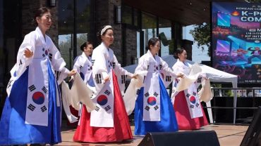 Women in traditional Korean dress performing on stage.