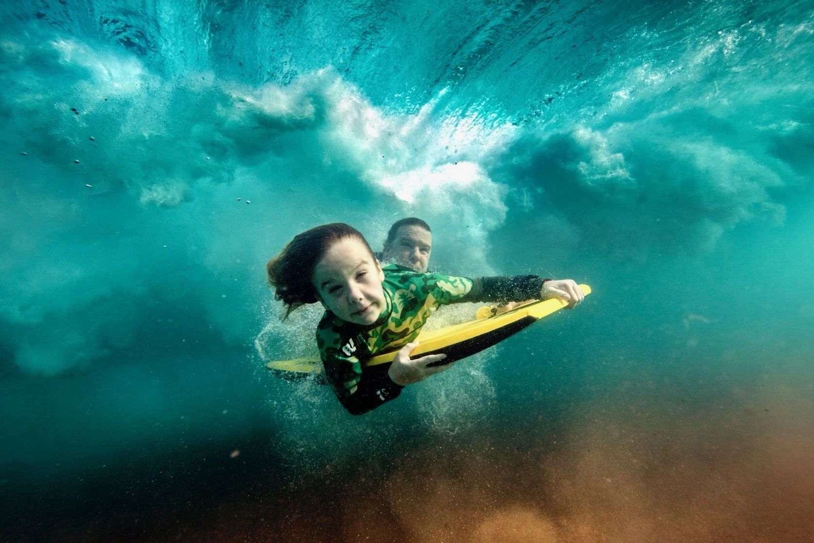 a little girl swimming under the water 