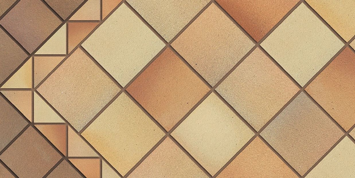 Tan and warm brown square terracotta floor tiles laid diagonally with a decorative border
