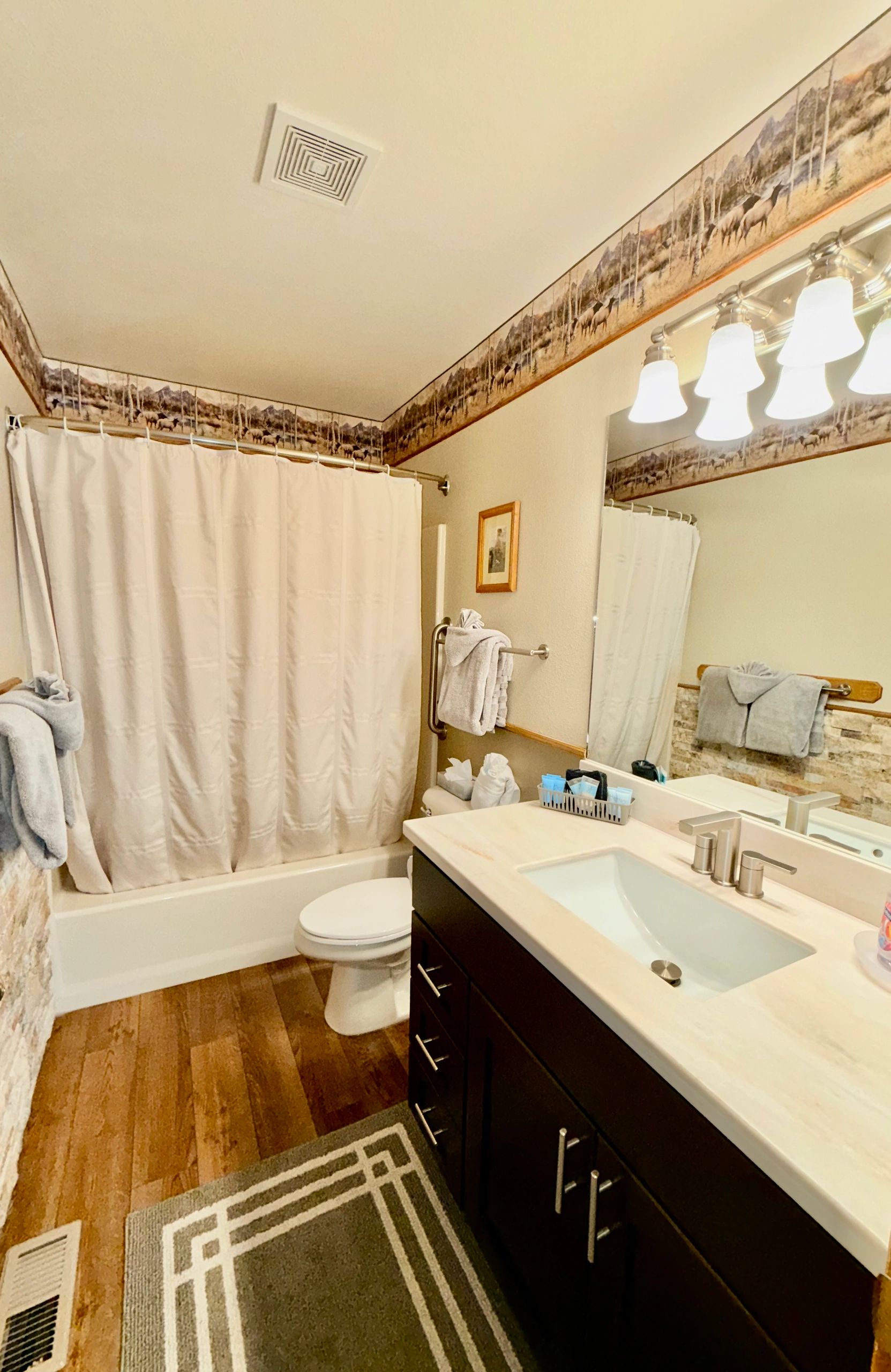A standard hotel bathroom with a tub/shower, toilet, and sink.