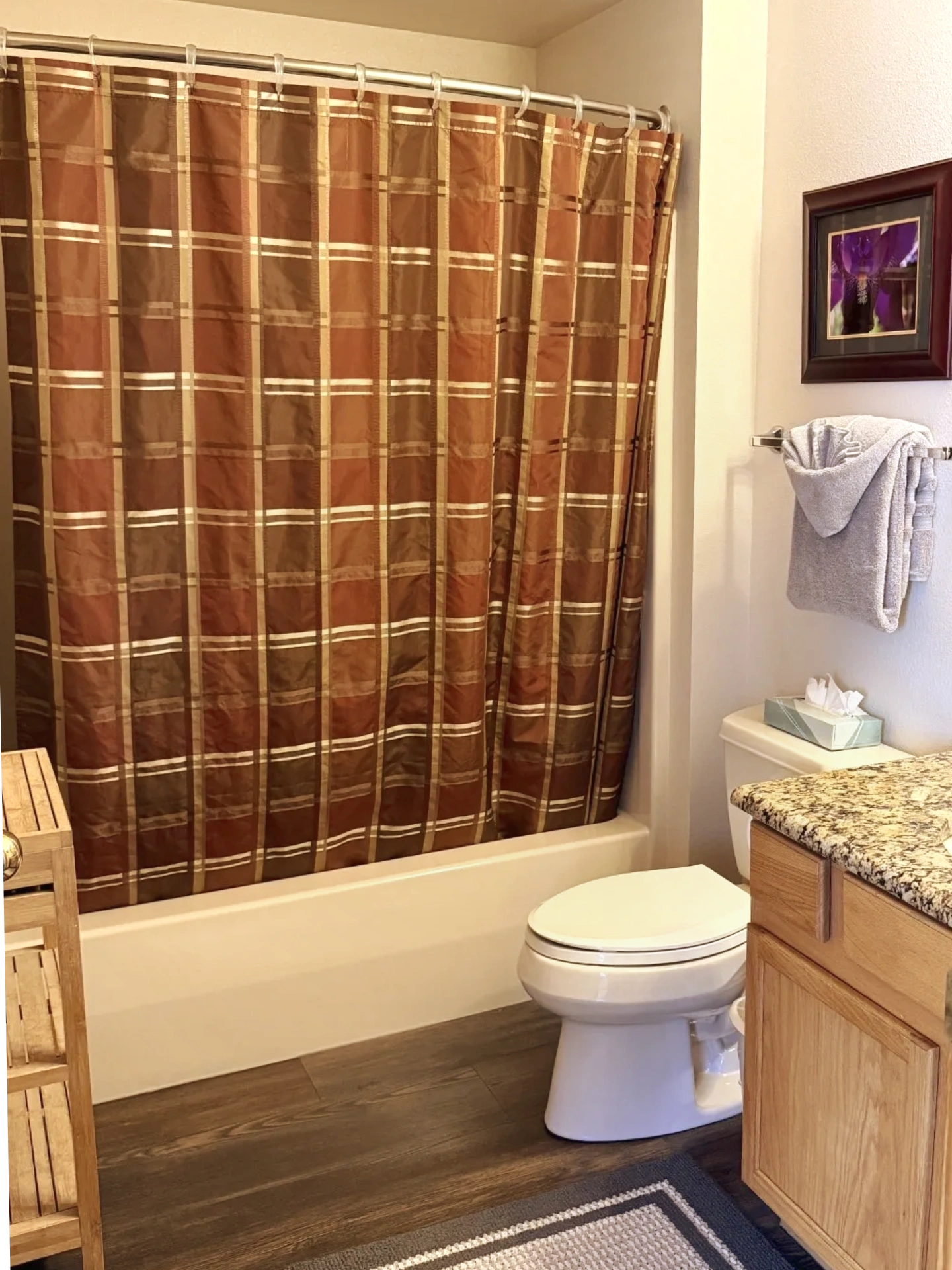 A clean bathroom with a toilet, shower curtain, and vanity.