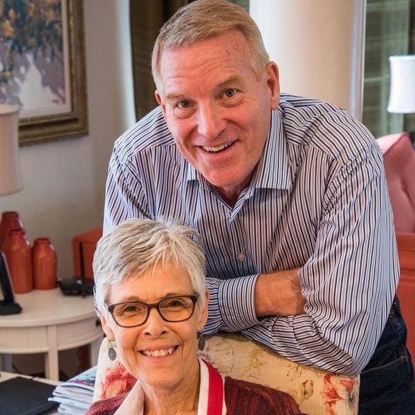 Smiling elderly couple posing together in a cozy home setting.