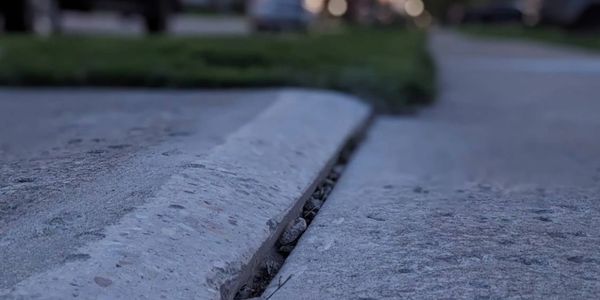 A perfectly ground concrete sidewalk slab with a smooth transition to eliminate a tripping hazard.