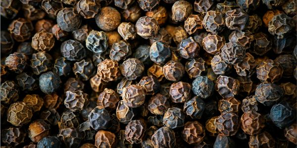 Close-up of dried black peppercorns piled together.