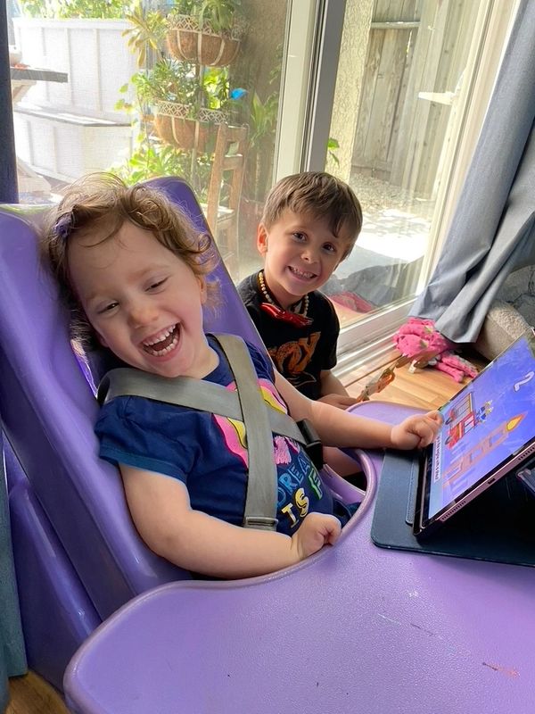 Special needs daughter laughing with big brother