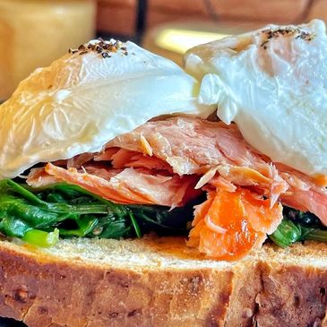 Eggs Royale = hot smoked salmon with spinach and poached eggs, served on white bloomer.