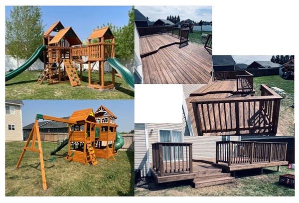 A backyard with wooden playsets and a wooden deck with railings.
