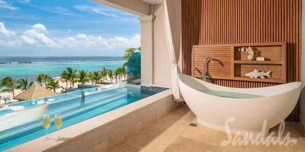 Luxurious bathroom with ocean view and a soaking tub at a tropical resort.