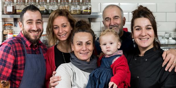 A happy family posing together in a bakery.