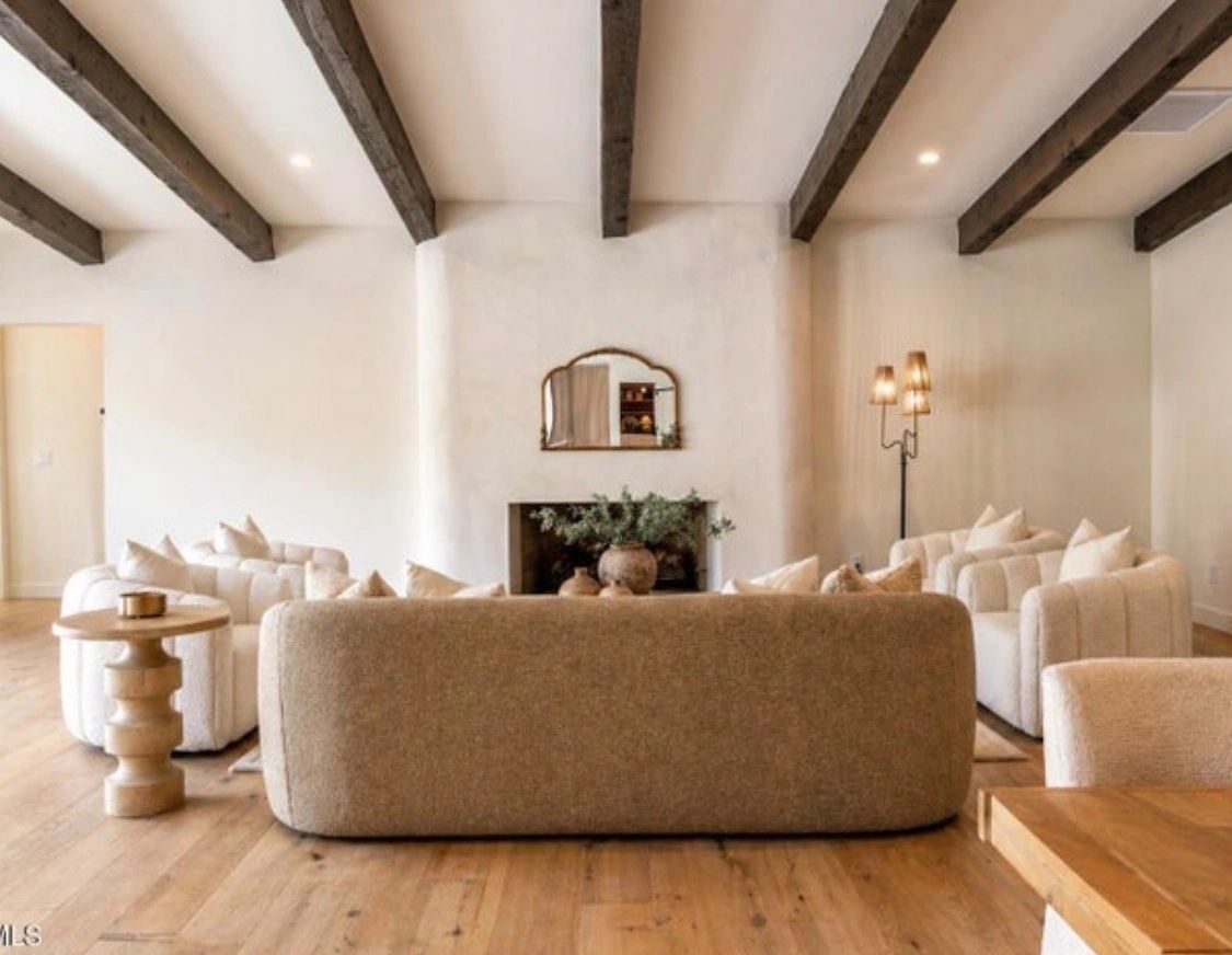 Cozy living room with neutral tones and rustic wooden beams.