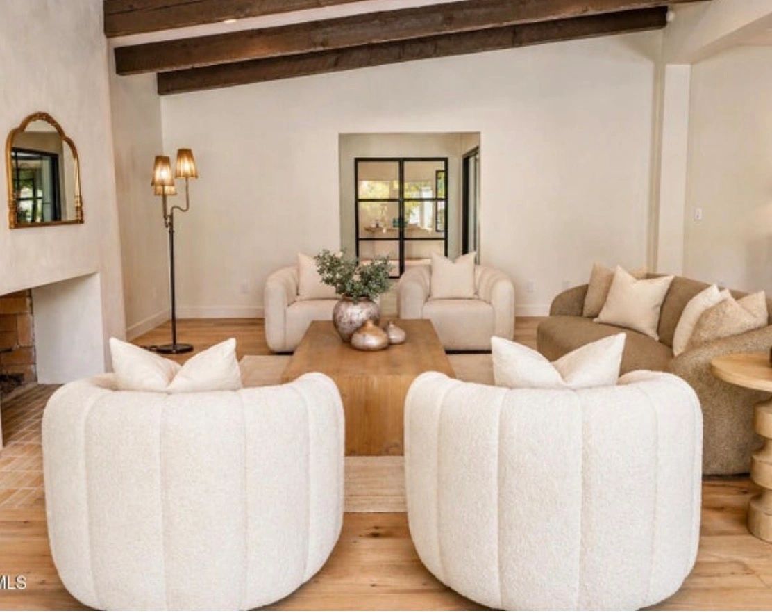 Cozy living room with neutral tones, plush chairs, and wooden accents.