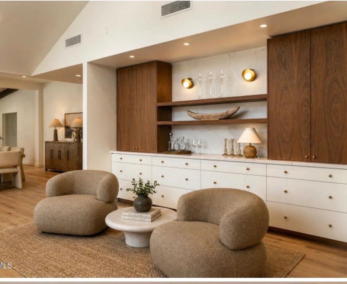 Cozy modern sitting area with rounded chairs and wooden cabinetry.