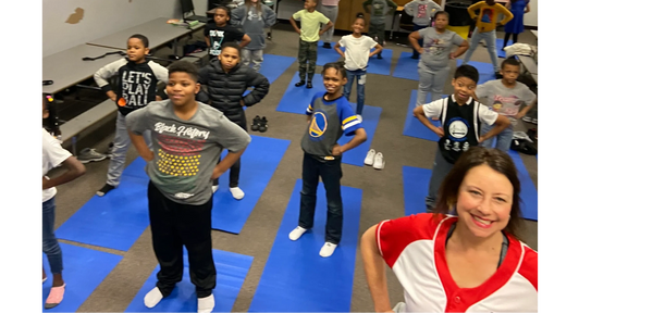 Children standing on yoga mats.