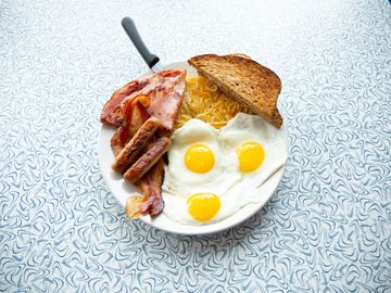 Bacon and eggs with hash browns and an English muffin. - Picture