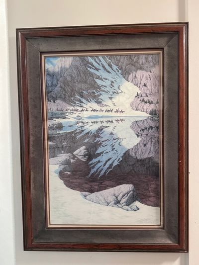Framed painting of snowy mountains reflected in a lake.