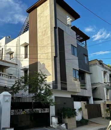 Modern multi-story residential building with blue sky background.