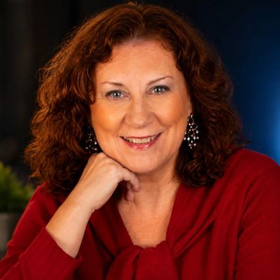 Smiling woman in a red sweater with earrings.