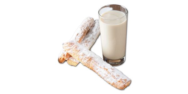 Vaso de leche con palitos de galleta azucarados.