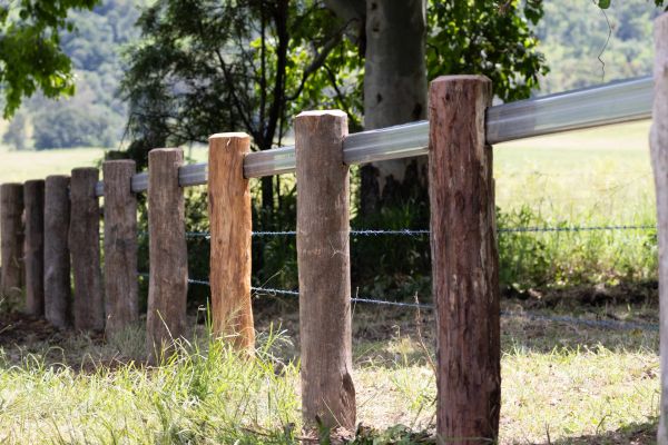 Rustic wooden fence in a green field.
