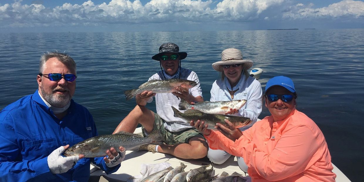 Reel Mell-O Fishing Charter clients holding up fish the caught in the Florida Keys.